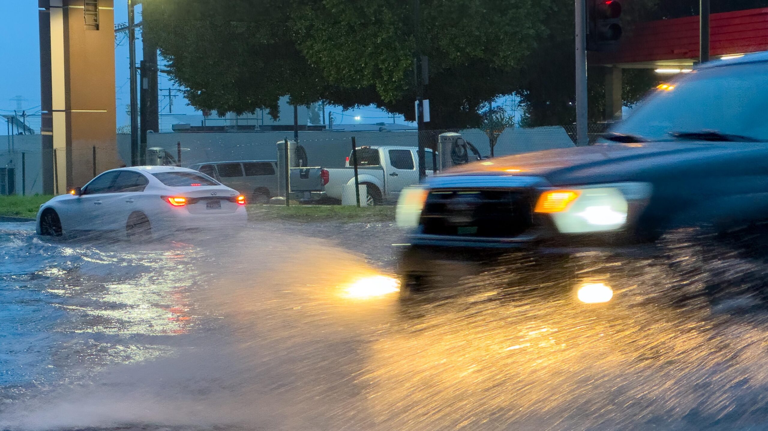 Cars drive through deep flooded streets during a winter storm.