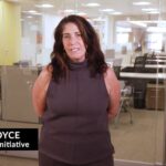 Female staff member from Homeless Initiative wearing a brown blouse with an office in the background