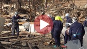 Workers with helmets moving debris from burned homes