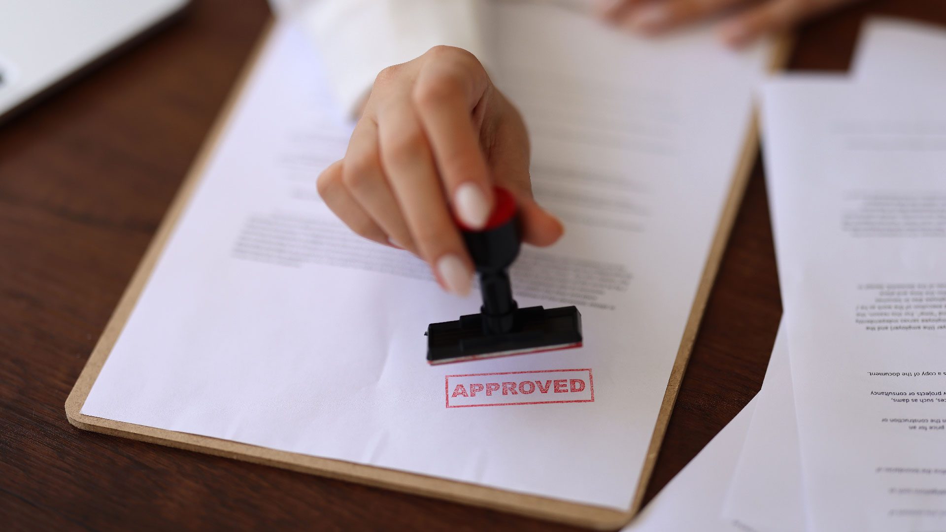 A woman uses a stamp to approve permits for construction.
